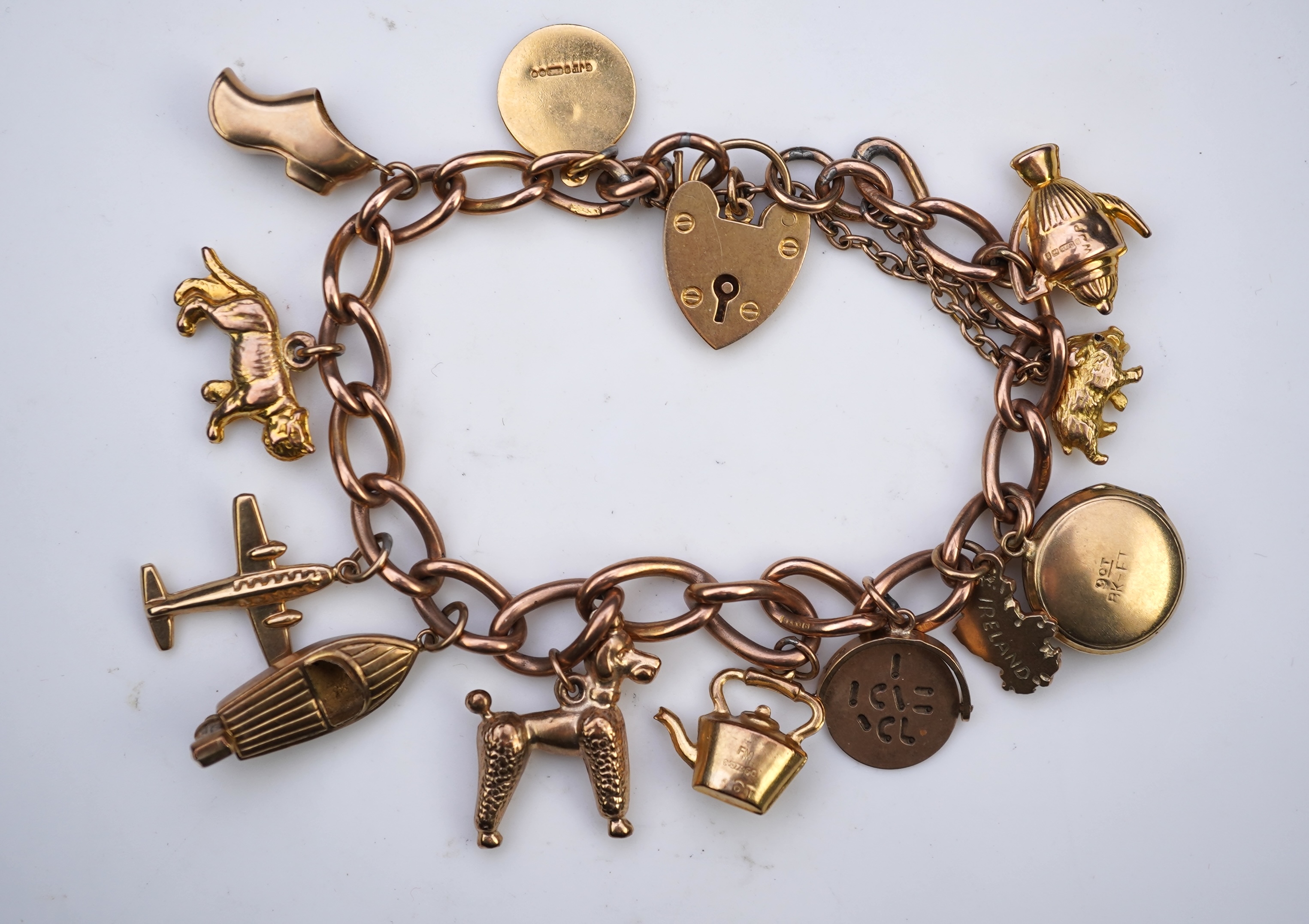 A gold charm bracelet, mid 20th century